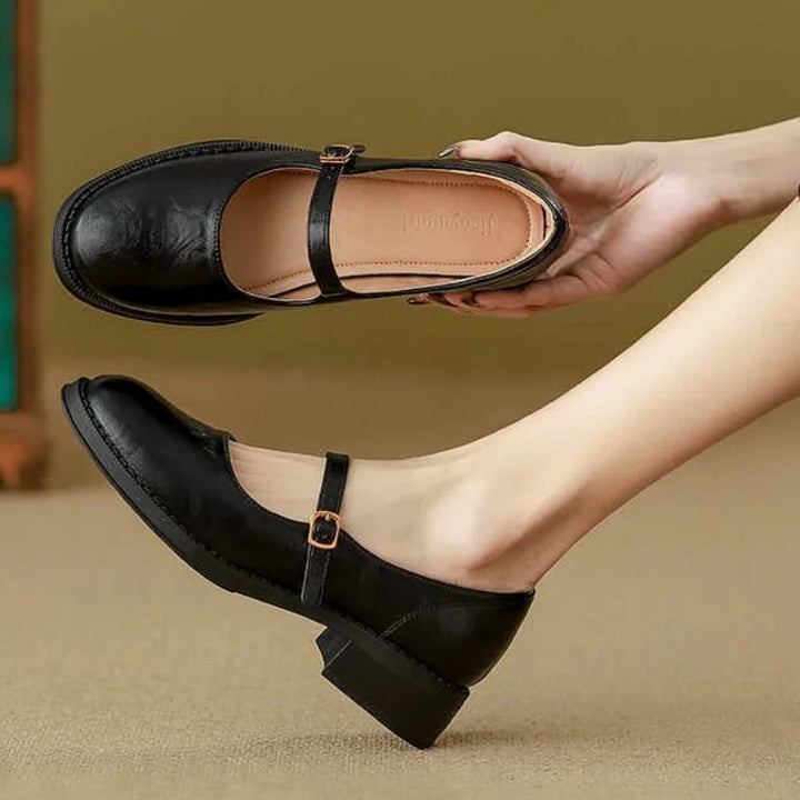 Women’s Mary Jane shoes on a plain background with an adjustable buckle strap.