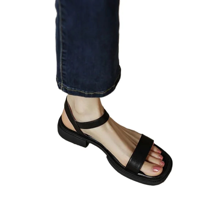 Female model wearing casual dress sandals on a plain background