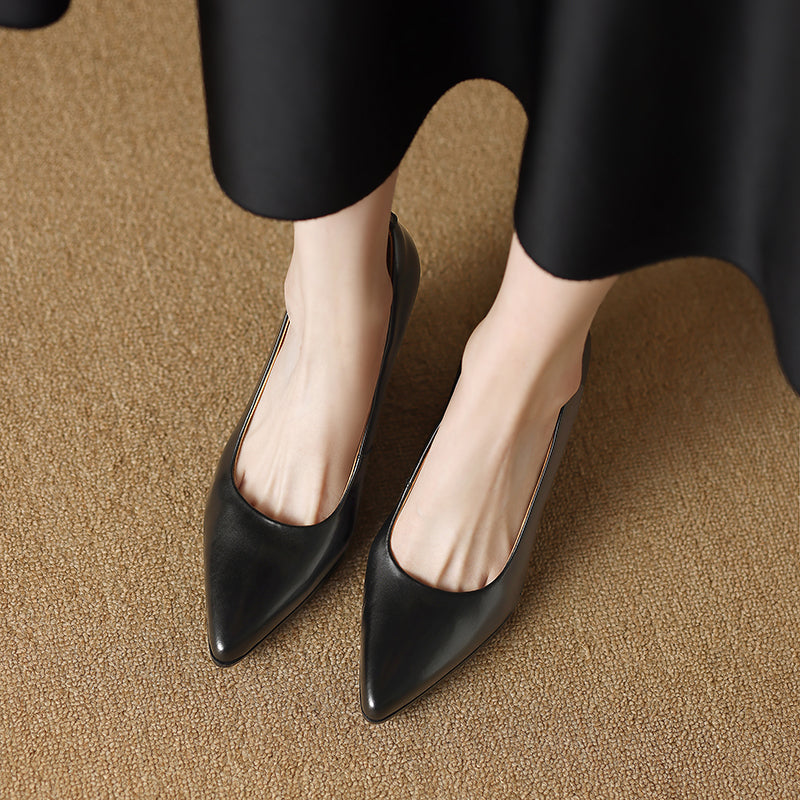 Female model wearing tan pointed toe heels for dressy outfits on a plain background.