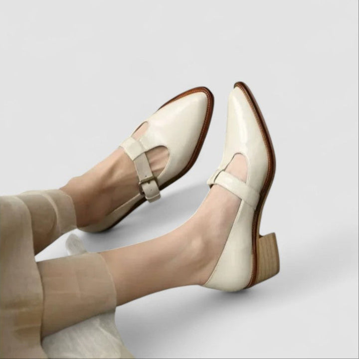 Woman wearing elegant classic shoes on a plain background.