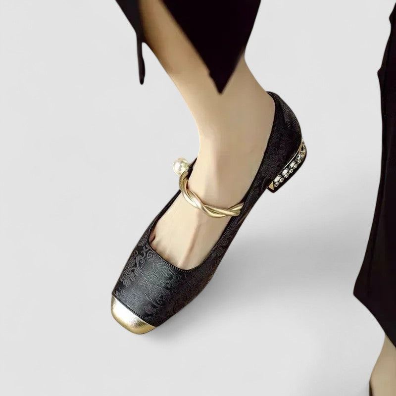 Woman modelling classic black shoes on a plain background.