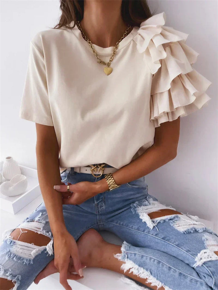 Female wearing a casual draped top with feminine sleeve accents.