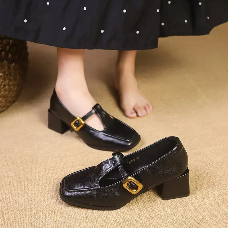 Woman wearing textured square toe heels with a strap on a plain background.