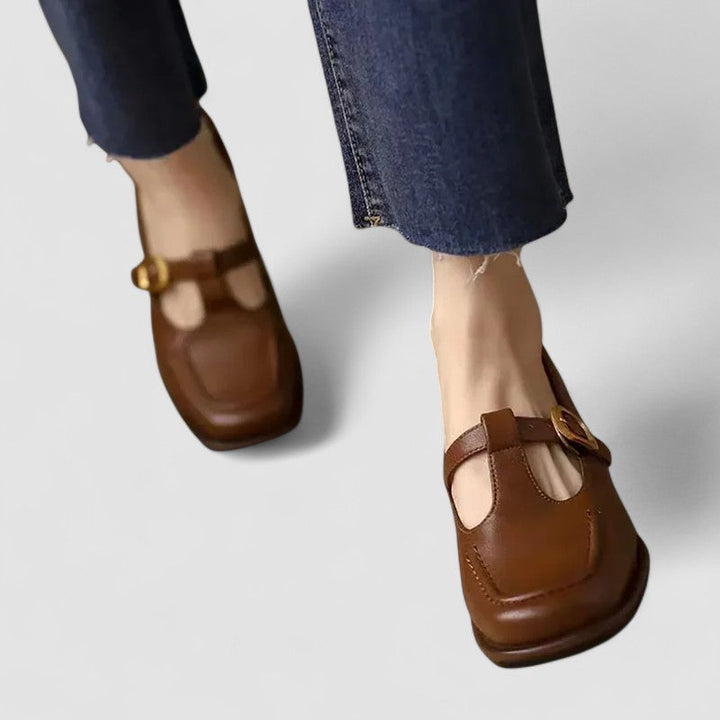 Women’s Mary Jane flats on a plain background with a polished finish.