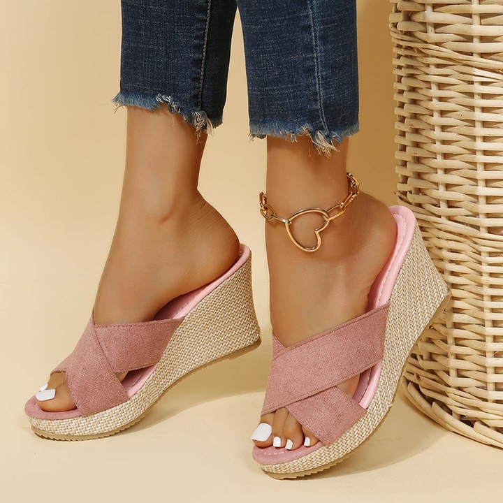 Female model showcasing warm-weather sandals on a plain background.