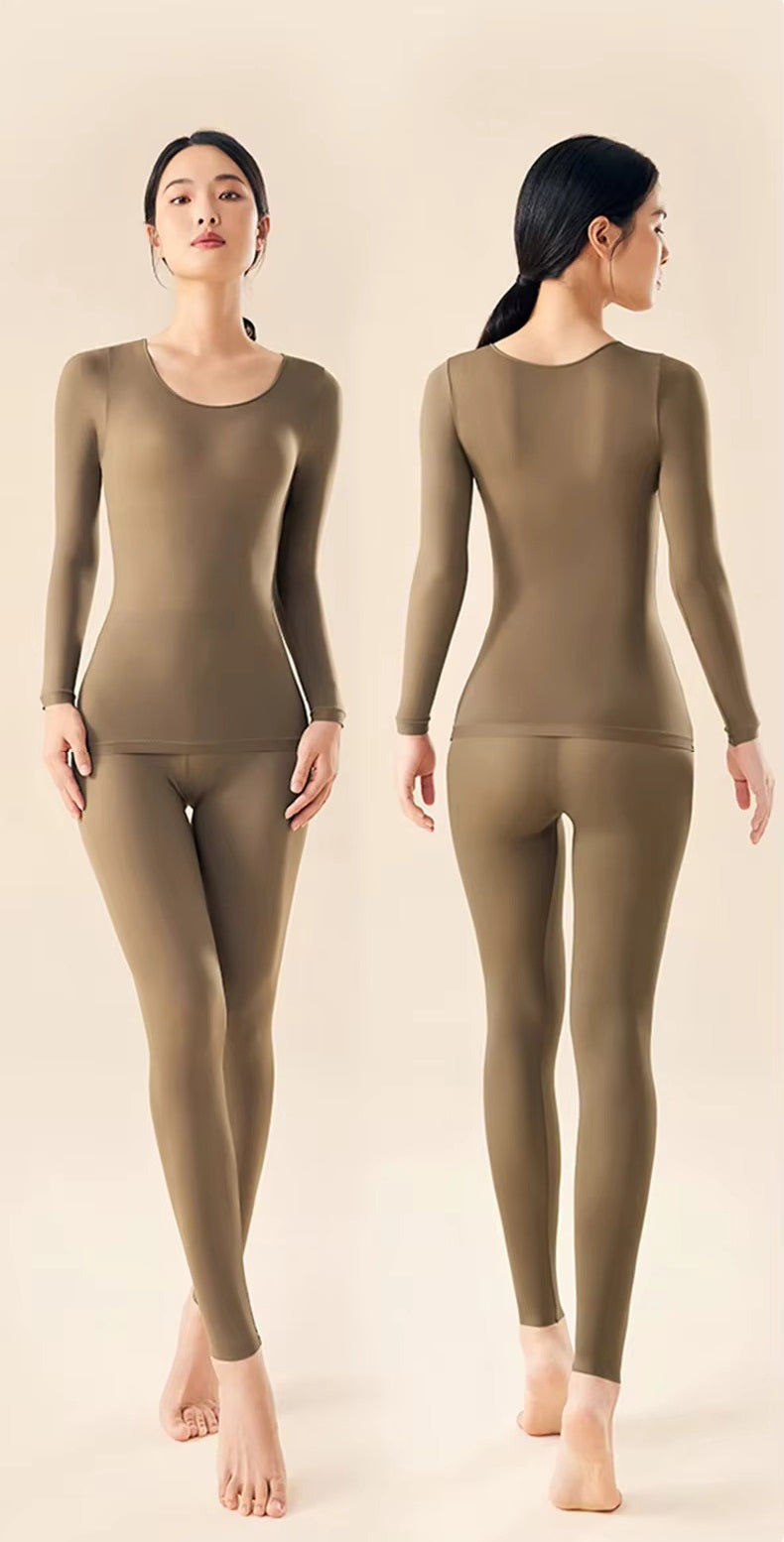 Woman wearing a thermal underwear set with a fitted long sleeve top and leggings on a plain background.