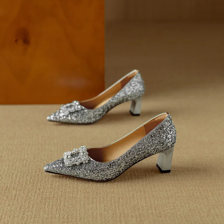 Glitter heels with a refined evening look on a plain background.