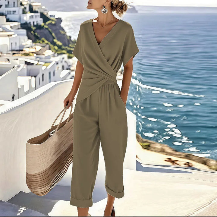 Female model wearing a summer two-piece set with a defined waistline on a back background.