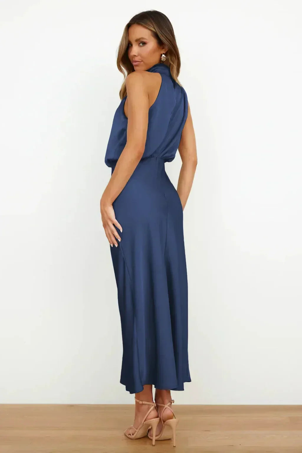 Female showcasing a relaxed silhouette outfit with graceful drape on a plain background.