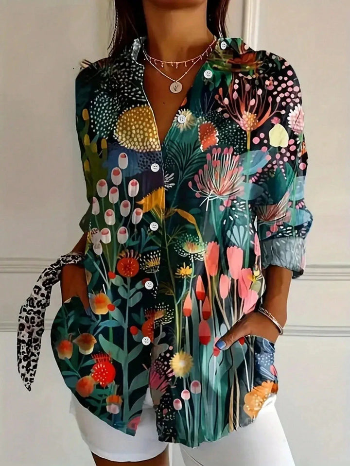 Female model showcasing a multicolor floral blouse with button-front detail on a plain background.