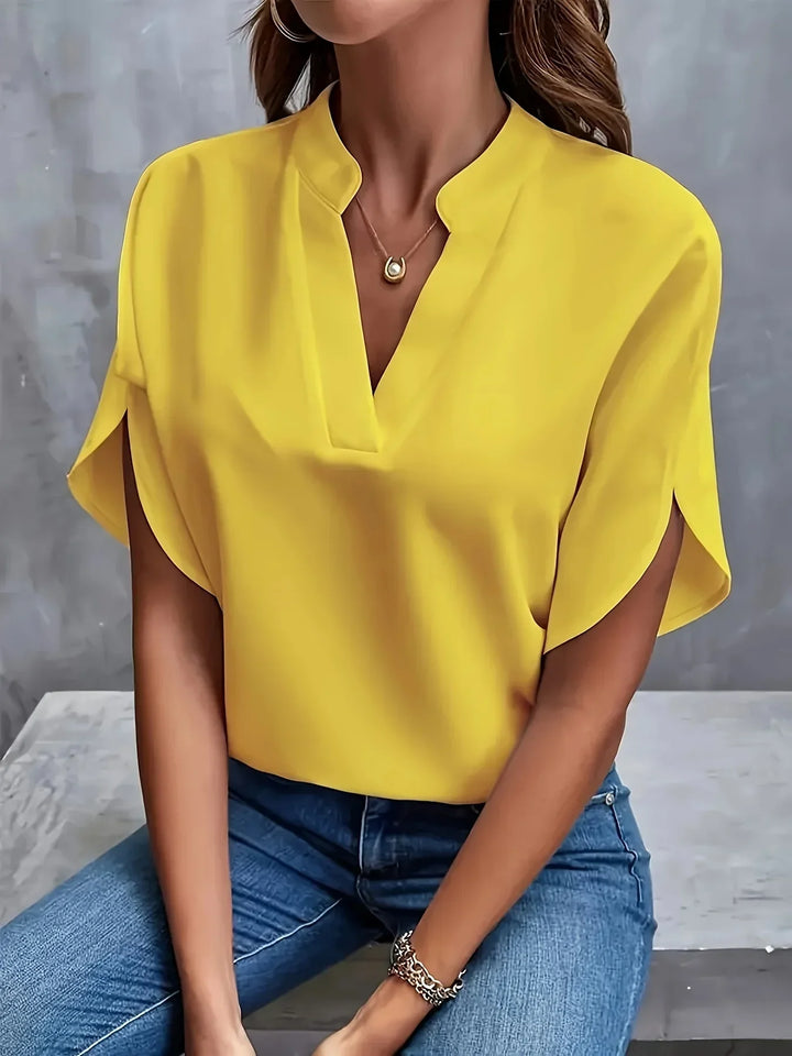  Woman in a lightweight blouse with elegant cap sleeve detailing.