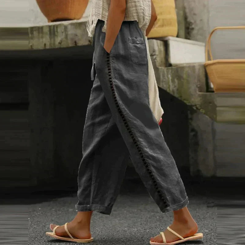 Female model in casual wide-leg trousers featuring decorative side trim and a flowing fit.