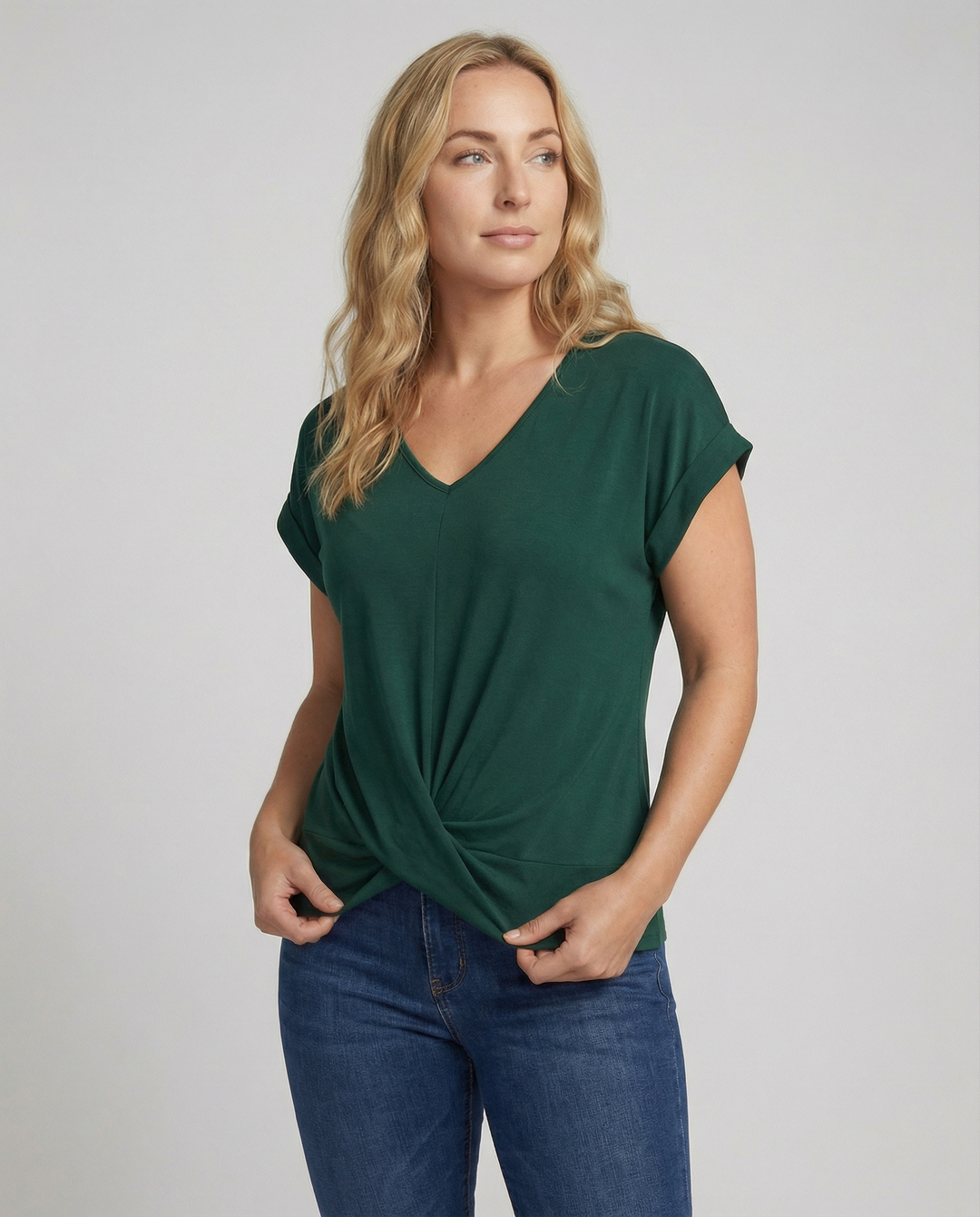 Woman wearing a short sleeve V-neck blouse against a plain background.