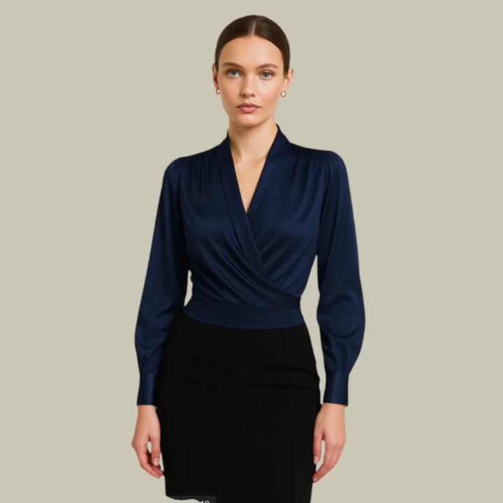 Female model wearing a V-neck wrap style blouse on a plain background.