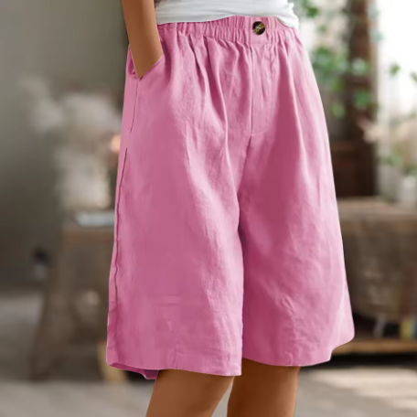 Relaxed women’s shorts styled for summer outfits on a plain background.