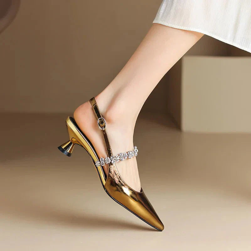 Model posing in chic slingback stilettos with sparkling details on a plain background.