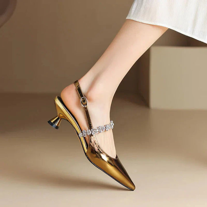 Model posing in chic slingback stilettos with sparkling details on a plain background.