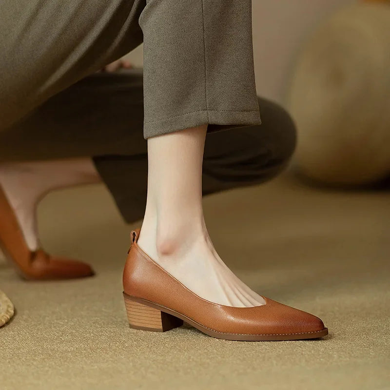 Model standing in minimalist block heel pumps on a plain background.