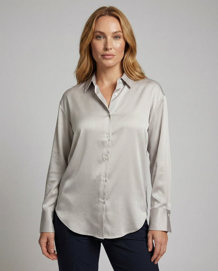 Woman wearing a vintage-style silk blouse against a plain background.