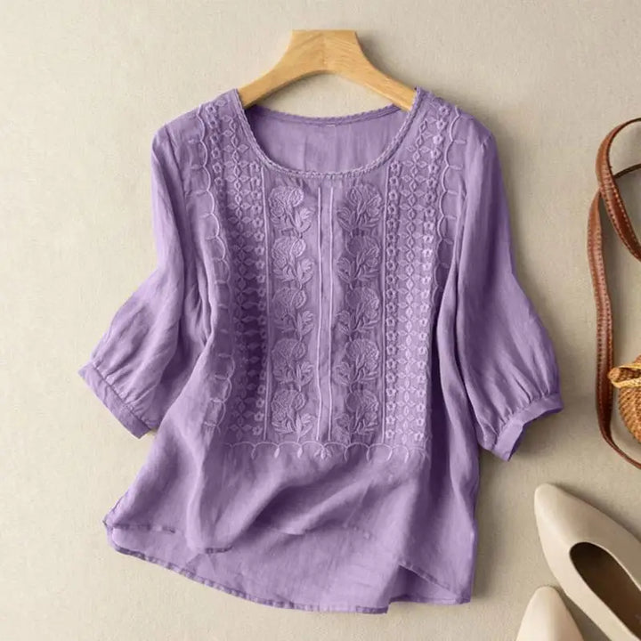 An embroidered top with a flowing silhouette and refined details.