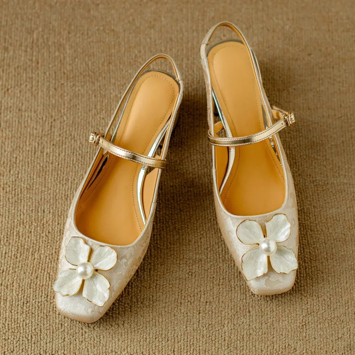 Mid heel floral pumps on a plain background.