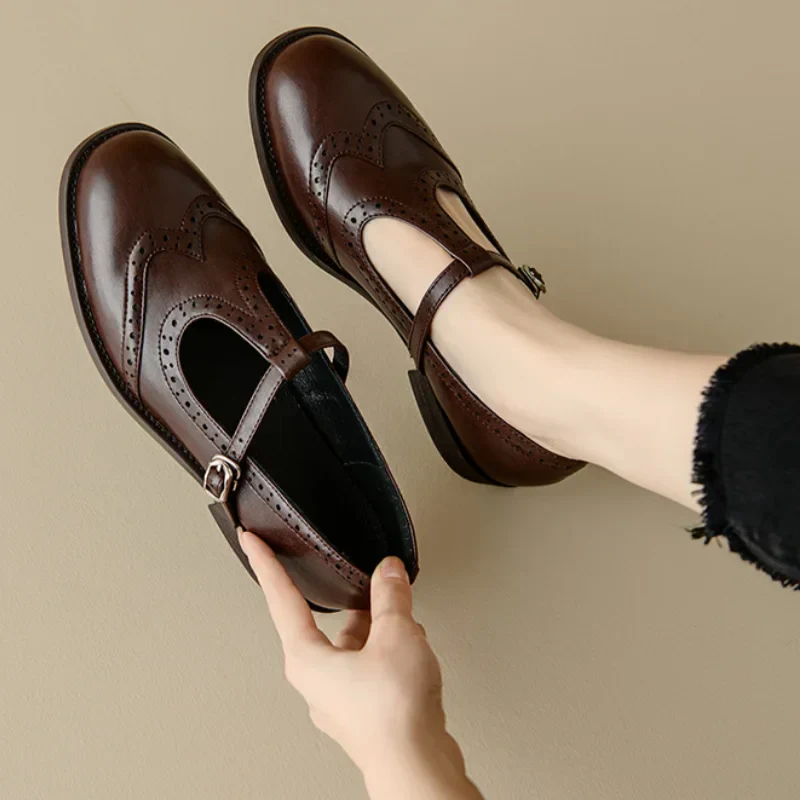 Woman wearing T-strap Mary Jane shoes on a plain background.