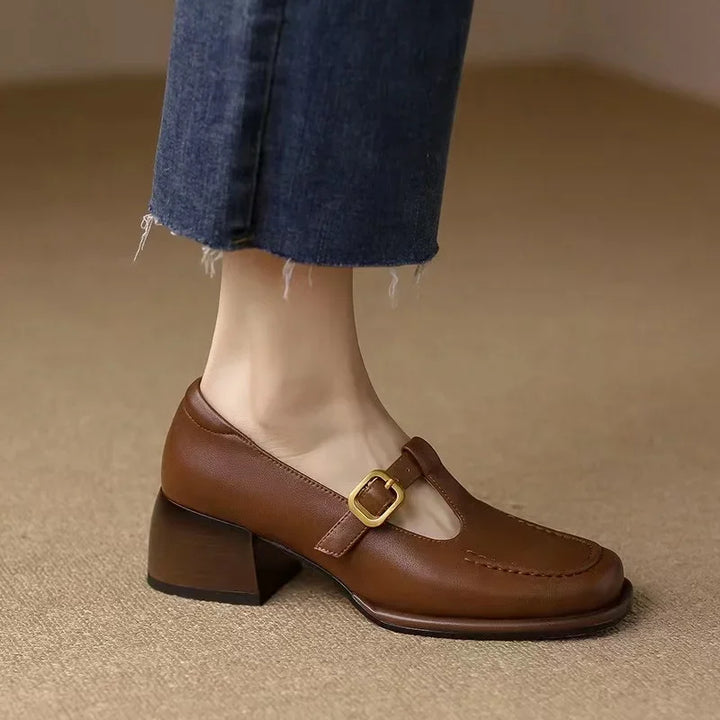 Woman showing T-bar strap shoes with an adjustable buckle.