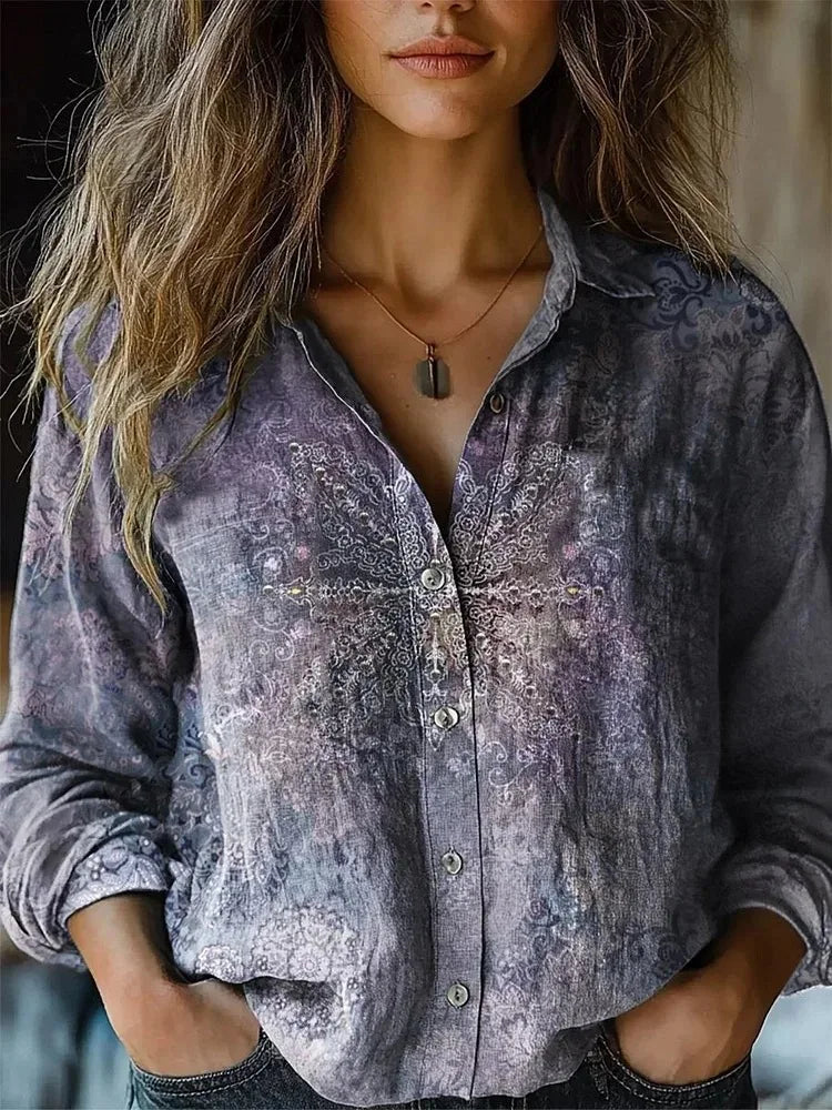  Woman wearing a long sleeve botanical print shirt on a plain background.