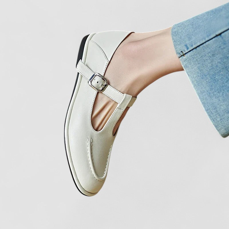 Female model wearing versatile low heel shoes on a plain background.