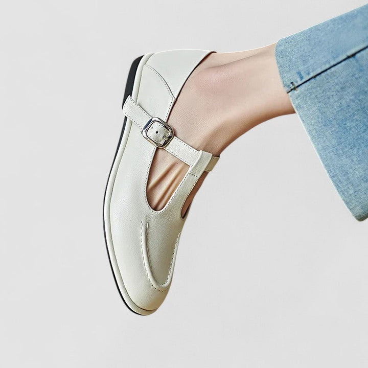 Female model wearing versatile low heel shoes on a plain background.