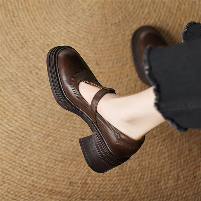 Woman wearing vintage style block heel shoes on a plain background.