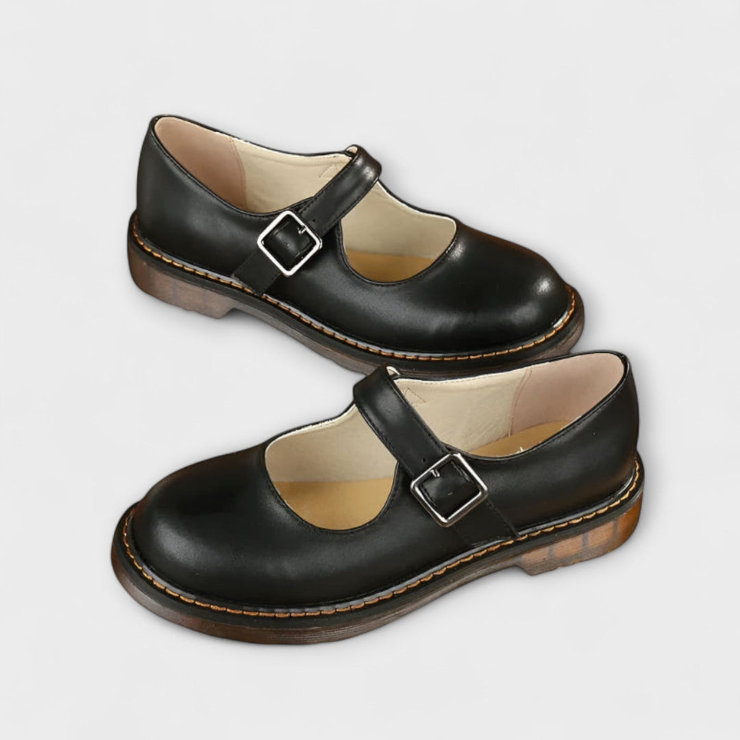 Female model wearing stylish everyday shoes on a plain background.