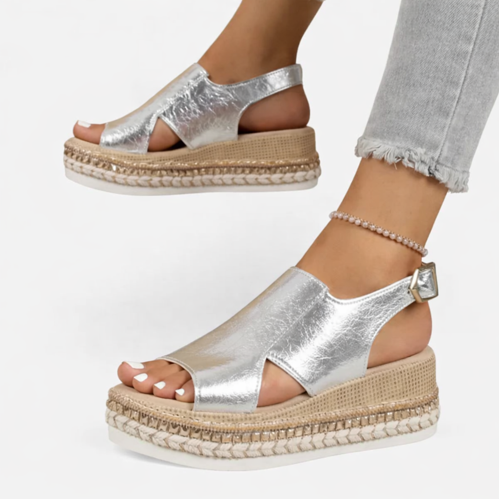 Model wearing espadrille platform wedge sandals with side cutouts on a plain background.