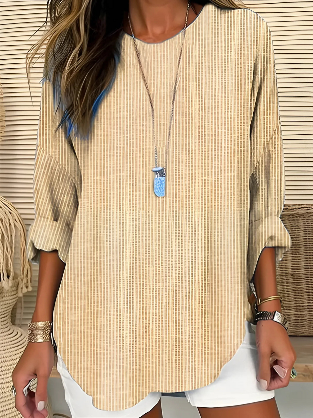 Woman in a relaxed striped blouse shown against a plain background.