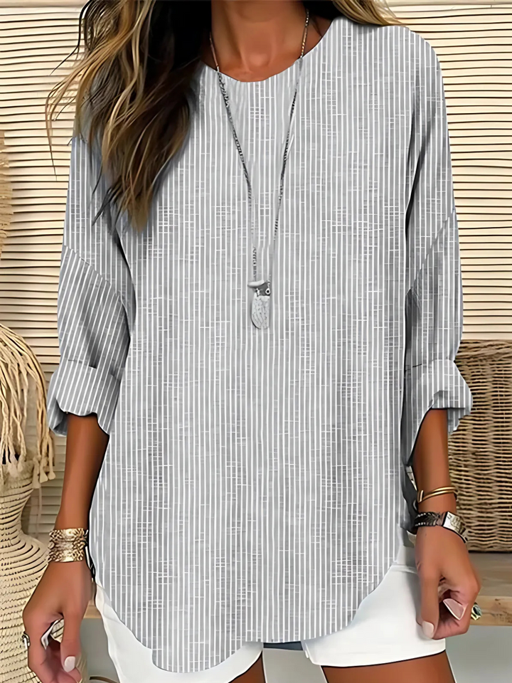 Model wearing a casual striped long sleeve top on a plain background.