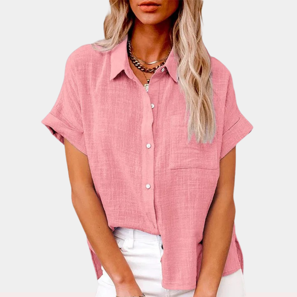 Woman wearing a striped blouse with a relaxed fit against a plain background.