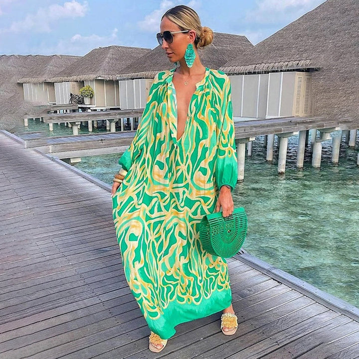 Woman wearing an abstract print kaftan dress on a plain background.