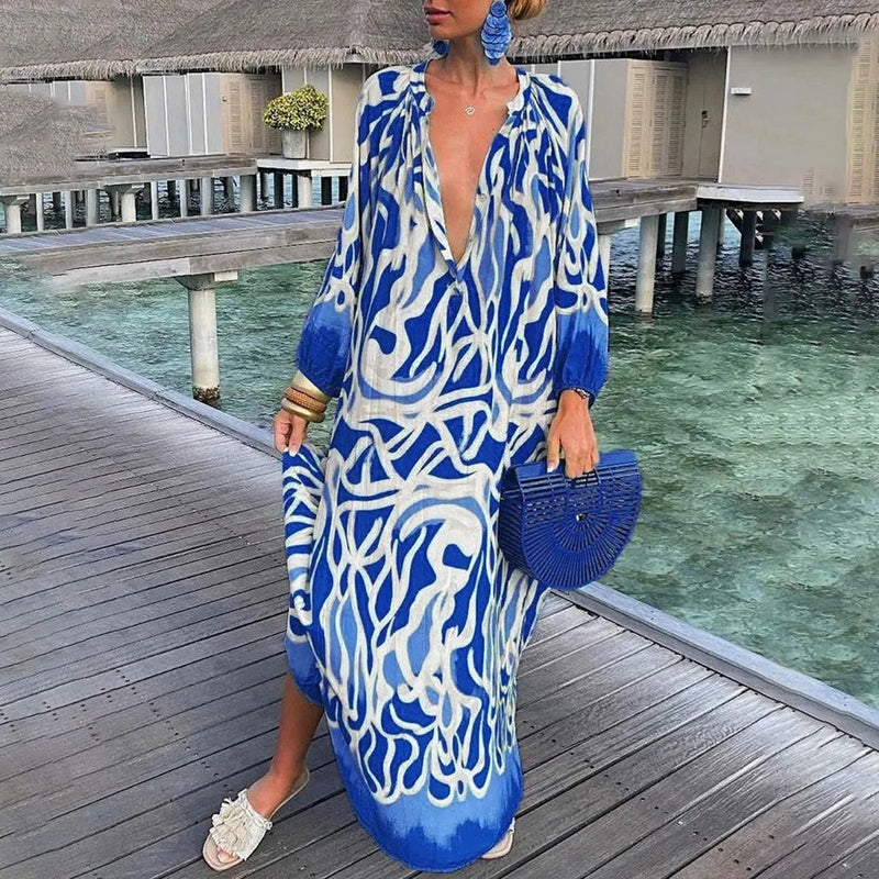 Female model wearing a breezy casual dress on a beach background.