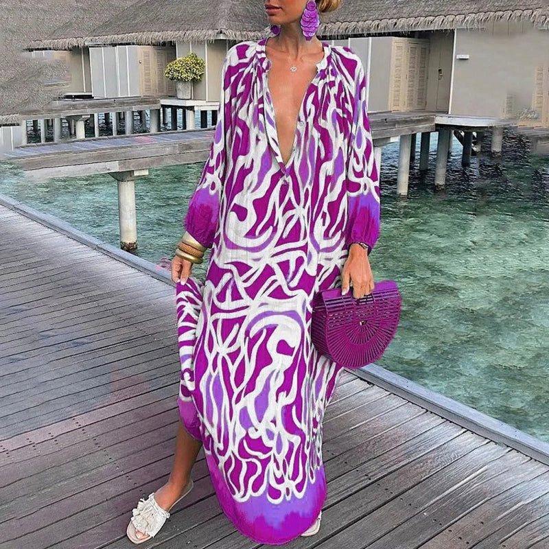 Woman styled in a relaxed kaftan dress with abstract print on a beach background.