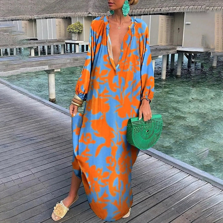Female model in a flowy abstract print dress on a beach background.