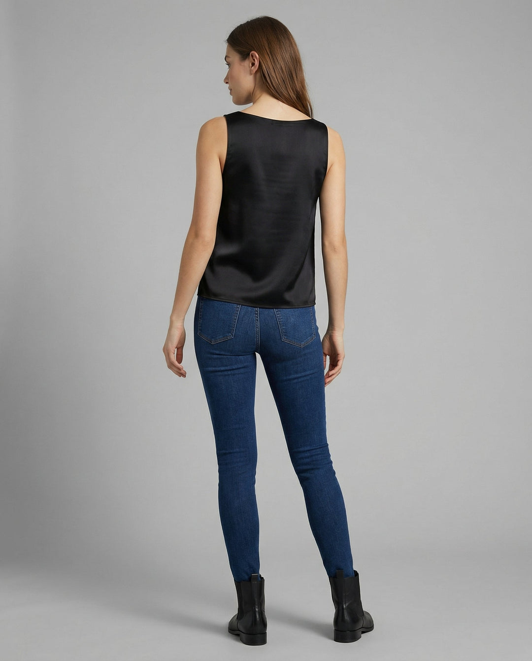 Woman in a minimalist silk tank top with a relaxed fit.