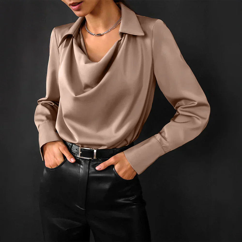 Woman showcasing a smooth satin blouse with long sleeves against a plain background.