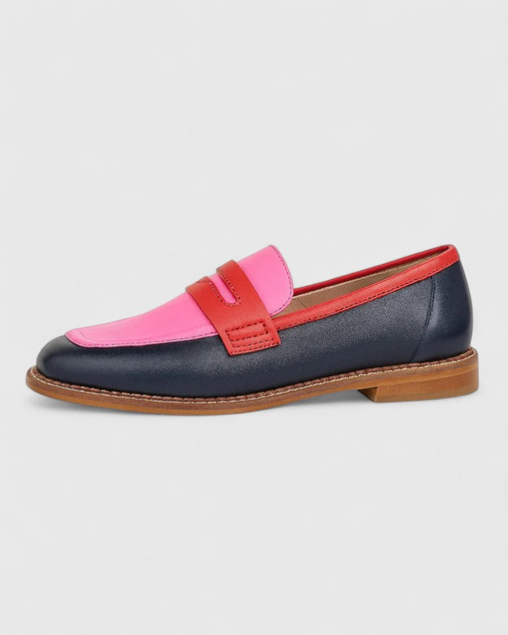 Styling sleek loafers with a refined outfit on a plain background.