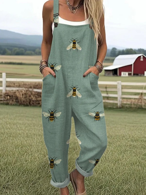 Female model wearing a floral print jumpsuit against a nature background.