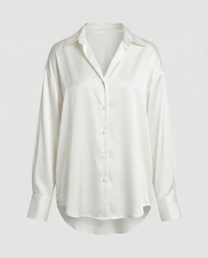 Woman in a long sleeve silk blouse styled on a plain background.