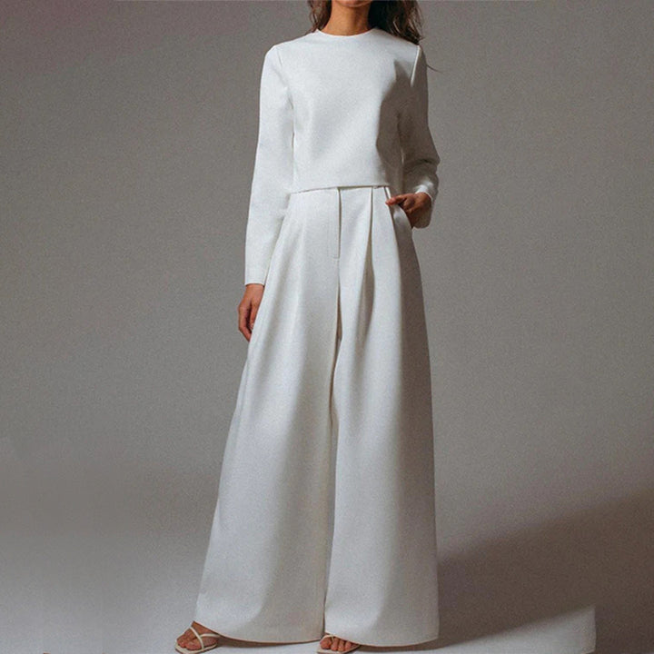 Woman modelling a casual outfit with high-waisted wide-leg trousers.