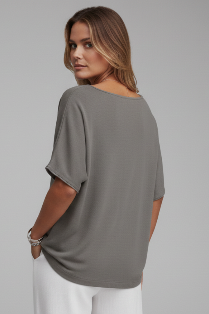 Female in a loose everyday blouse with a straight hem on a plain background