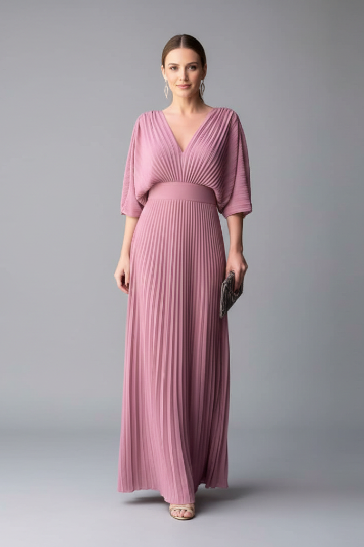 Model in a long sleeve maxi dress with a V-shaped front and waist seam on a plain background.
