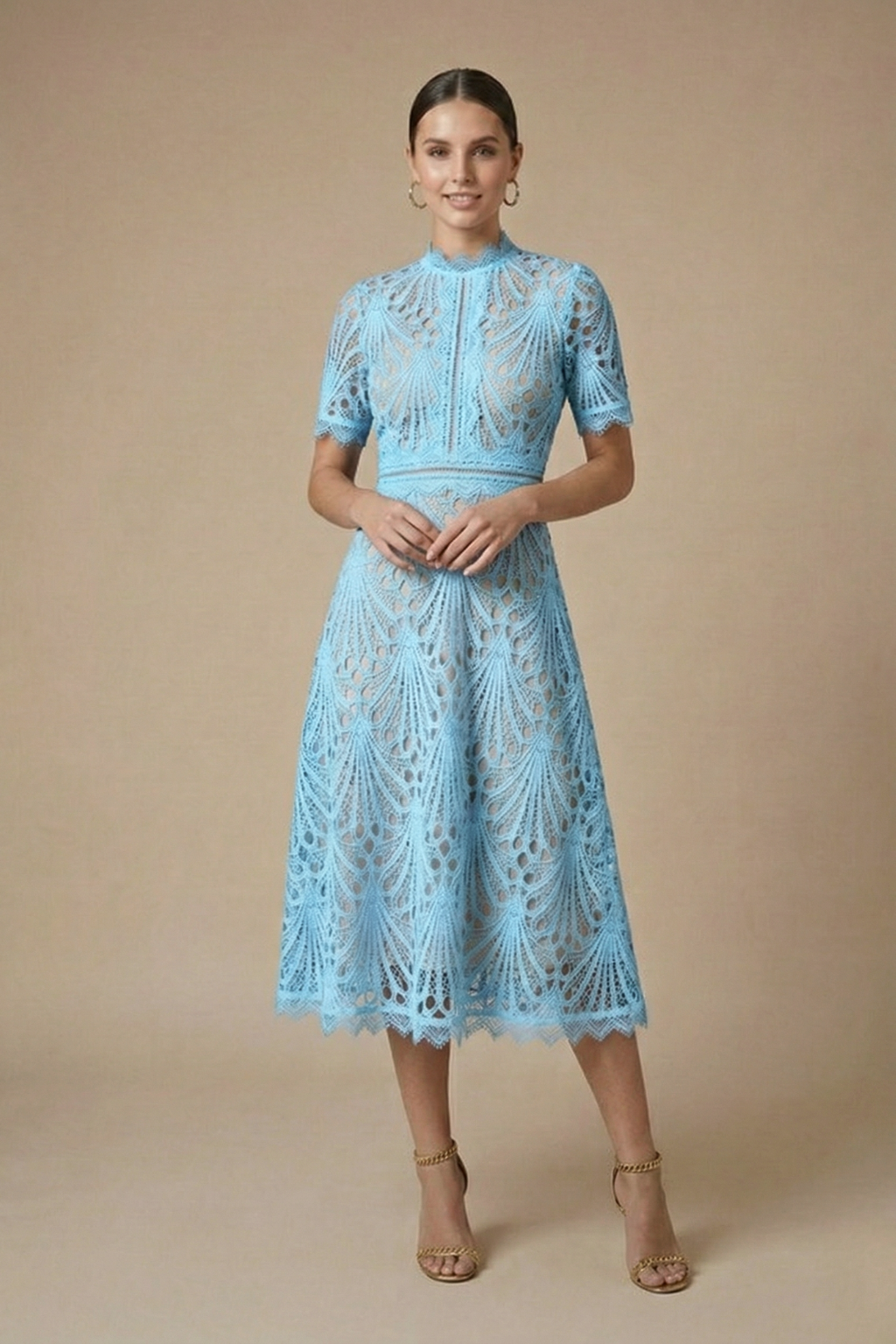 Female in a structured A-line occasion dress with cutwork detailing on a plain background.