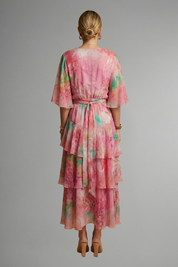 Female model in a sleeveless midi dress with a defined waist seam and flowing pleated ski